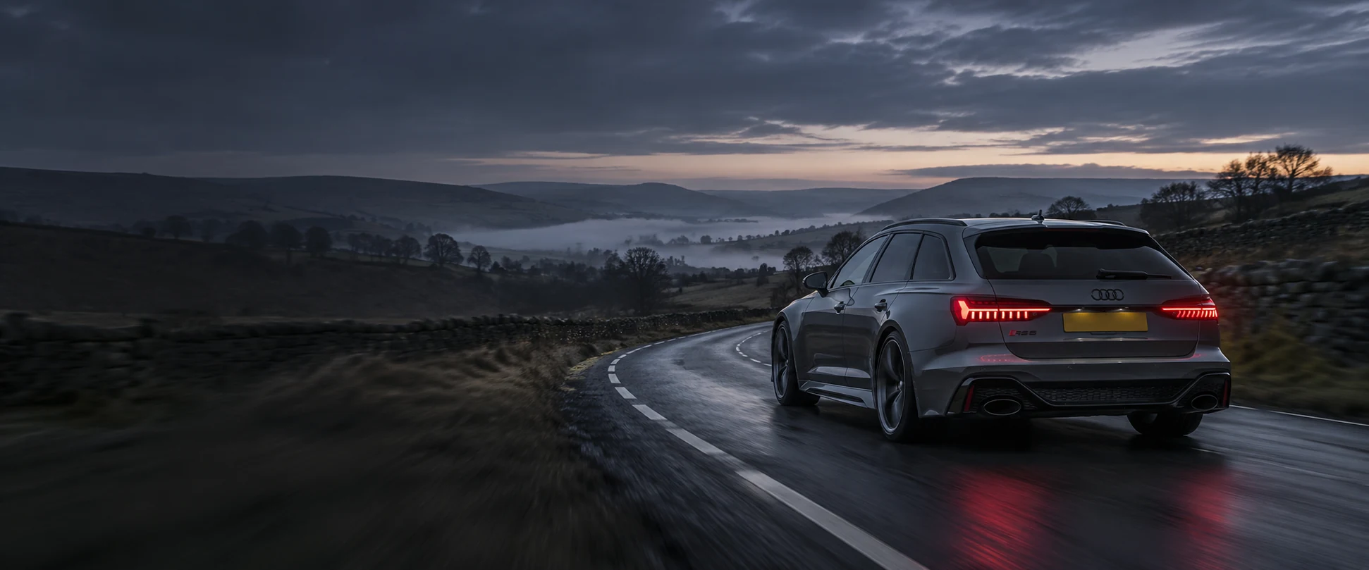 Graphite Audi estate on a winding countryside road at dusk — generated automotive illustration